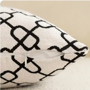 Black and white geometric pattern throw pillow case with hidden zipper detail for home decor.