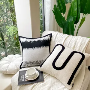 Close-up detail of modern black and white throw pillow with unique U-shape design and cozy texture.