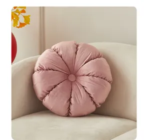 Pink pleated round throw pillow detail view, soft plush sofa cushion in cozy living room setup.