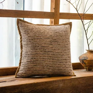 Gemütliches Strick-Zierkissen für Sofa, rustikaler Kissenbezug mit brauner Paspelierung.