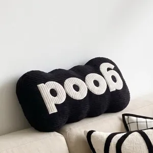 Black corduroy bone shaped throw pillow with white embroidered letters, modern sofa cushion.