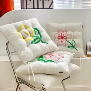 Plush seat cushion detail shot, white sherpa fabric with colorful embroidered flower pattern.