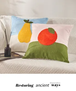 Detailed view of Nordic fruit tufted cushion featuring pear and orange embroidery.