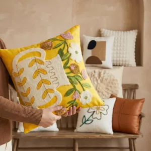 Yellow embroidered throw pillow detailed scene, soft cushion for living room sofa and bed.