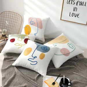 Abstract face decorative throw pillow detail shot showing artistic embroidery design in modern room.