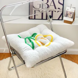 Detail view of a plush chair cushion with cute fruit embroidery, soft and thick for dining room.