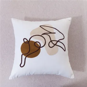 Modern minimalist abstract face throw pillow with textured line embroidery and color block design.