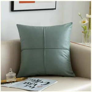 Detail shot of sage green PU leather sofa cushion featuring minimalist cross stitching design.
