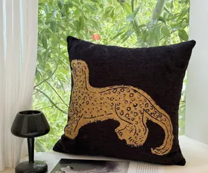 Designer vintage artistic throw pillow cover with chic gold leopard print on black fabric sofa cushion.