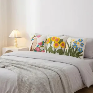 Gemütliches Schlafzimmerszenen Detail mit bestickten Kissenbezügen auf dem Bett.