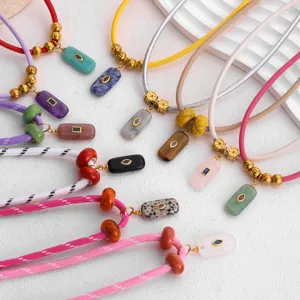 Collana con cordino colorato in pietra naturale, perline dorate e ciondoli geometrici geometrici.