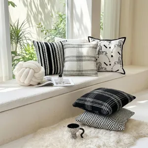 Detailed view of modern black and white throw pillows with zebra and tweed plaid patterns.
