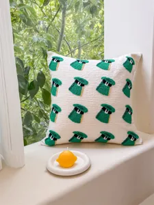 Housse de coussin tuftée avec détail de motif vert, décoration chaleureuse pour canapé et salon.
