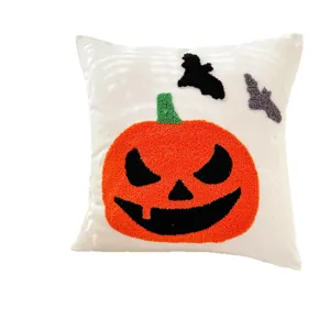 Housse de coussin Halloween avec broderie touffetée de citrouille et chauve-souris.