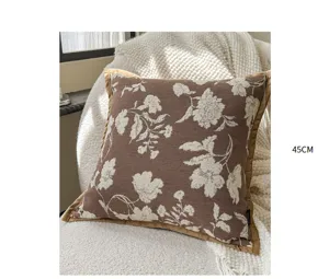 Close-up of French vintage brown floral throw pillow, elegant textured fabric detail.