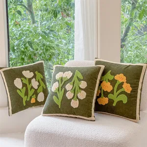 Olive green throw pillow with tufted floral embroidery and cream border for cozy sofa decor