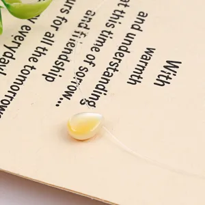 Natural shell pearl teardrop pendant necklace on transparent fishing line, minimalist jewelry.