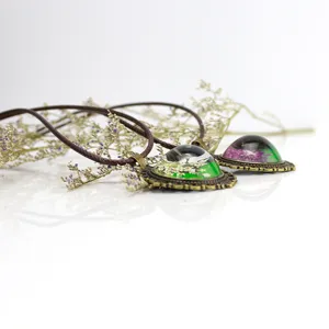Collana gotica vintage in pietra preziosa con ciondolo di fiori secchi e cordino marrone.