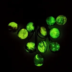 Glow in the dark galaxy glass pendant necklace, luminous universe stardust jewelry accessory.