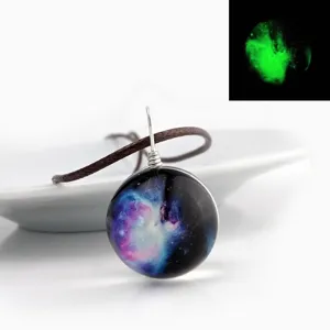 Round galaxy glass pendant necklace with brown cord and glowing night effect detail view.
