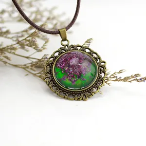 Collana con ciondolo in vetro cabochon di fiori secchi vintage con cornice in filigrana.