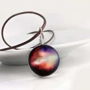 Glass galaxy pendant necklace with star universe design, brown cord and wire wrapped detail.