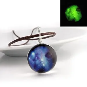 Detail view of glowing galaxy glass dome pendant necklace with night luminous effect display.