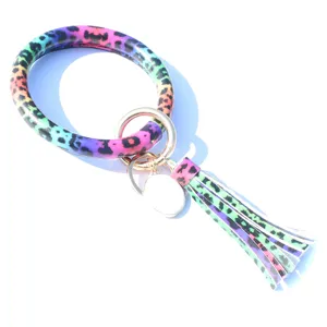 Joli porte-clés bracelet en cuir PU avec motif léopard arc-en-ciel et pompon stylé.
