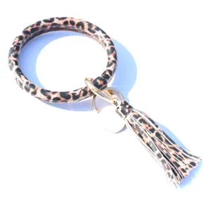 Porte-clés anneau en cuir PU léopard avec pompon frangé et pendentif en métal accessoire.