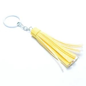 Close-up detail view of vibrant yellow leather tassel keychain, showing fine product texture.