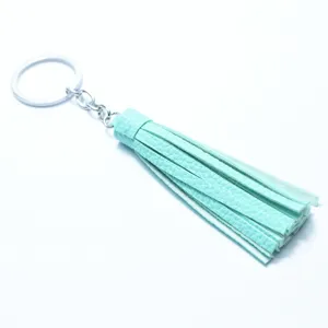 Close up view of mint green leather tassel keychain with silver ring for bags and keys.