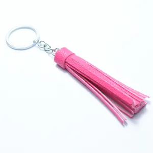 Detailed close-up view of pink leather tassel keychain and chic bag charm for women.