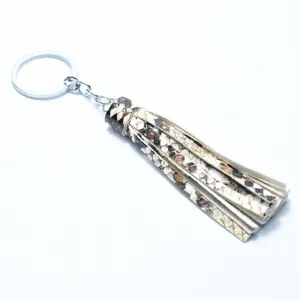 Detailed shot of a stylish snake print leather tassel keychain with a shiny silver metal ring.