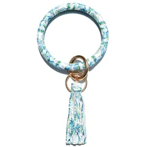 Blauwe bladafdruk PU lederen ronde armband sleutelhanger met metalen ringen kwast detail.