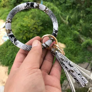 Vista dettagliata del portachiavi bracciale in pelle PU con motivo serpente e nappina.