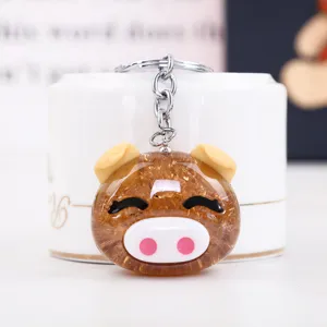 Cute glitter pig keychain detail shot, sparkling resin design with sturdy metal ring pendant.