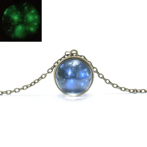 Glow in the dark glass ball pendant necklace detail, vintage bronze chain universe design