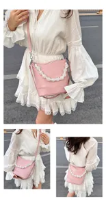 Pink leather bucket bag with white pearl handle, stylish women's single shoulder messenger bag.