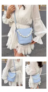 Light blue bucket bag featuring a chic pearl handle and adjustable shoulder strap for women.