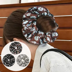 Detailed shot of the floral oversized scrunchie showing fabric texture and back wearing style.