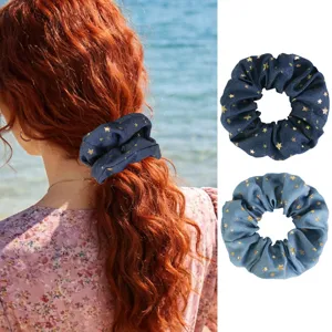 Detail shot of denim hair scrunchie with gold stars, retro French style hair accessory.
