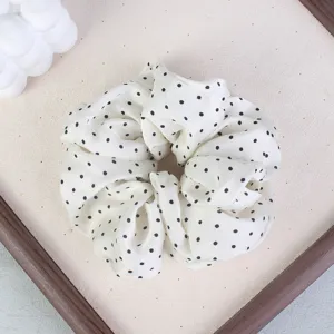 White polka dot hair scrunchie for women, elegant ponytail holder and hair tie for daily wear.