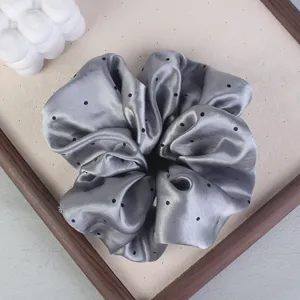 Gray polka dot satin hair scrunchie detail view, elegant hair tie for women's daily styling.