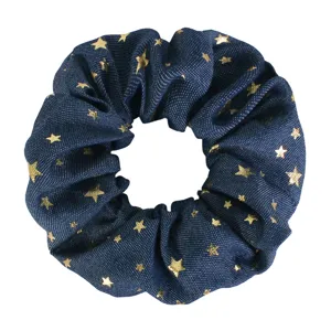 Blue denim style fabric hair scrunchie featuring elegant gold star prints, perfect detail view.