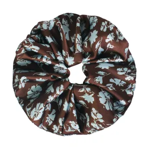 Close-up detail of brown and light blue floral hair scrunchie, soft fabric design for daily styles.
