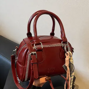 Red patent leather handbag for women, chic commuting shoulder and crossbody bag with stitching.