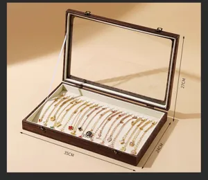 Wooden jewelry display box with clear glass lid and soft velvet interior for necklaces.