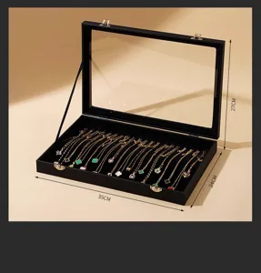 Detailed view of black velvet necklace display box with clear glass lid and secure locks.