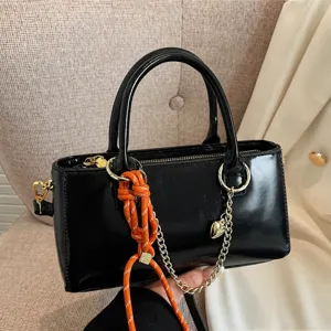 Sac à main en cuir vernis noir pour femme, sac porté épaule bandoulière avec chaîne et charme.