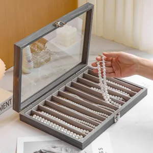 Grey wooden jewelry box with glass lid, velvet multi-slot necklace and bracelet organizer.
